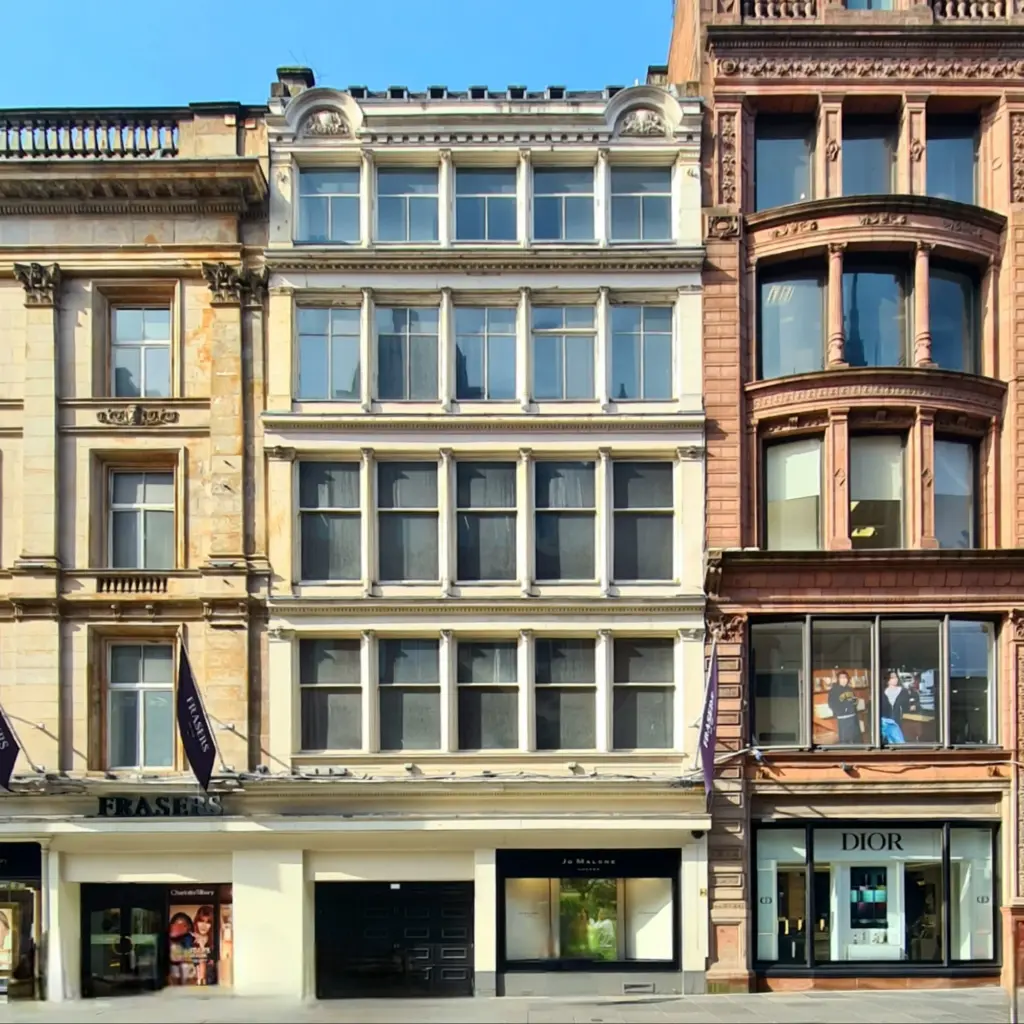 Frontal view of three commercial buildings, sandstone on left, 5 storeys in white (Kemp's), and a taller grander building in red sandstone (W&L).