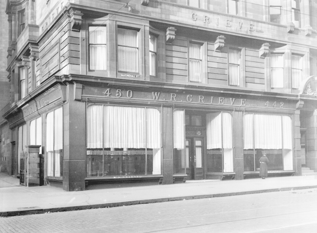 Red sandstone building at street level, W R Grieve above the curtained windows
