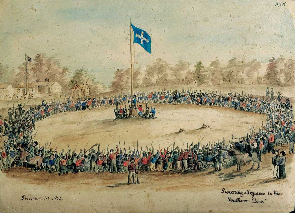 The whiote and blue Eureka flag is raised in the centre of a large ring of hundreds of miners