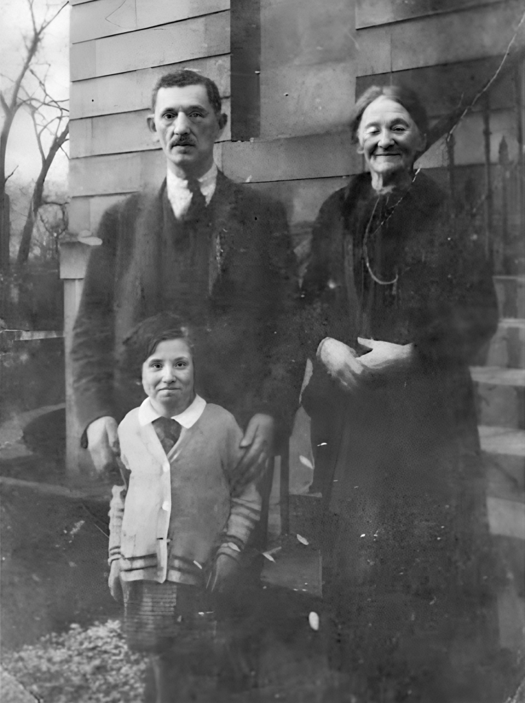 Elderly lady, her middle aged son, and grinning grand daughter, on the steps of 52 Marywood Square, which looks much the same today.