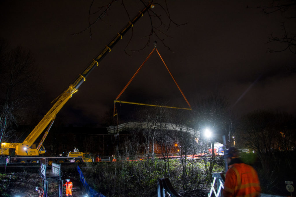 The crane lowers the deck onto Darnely Road under floodlights