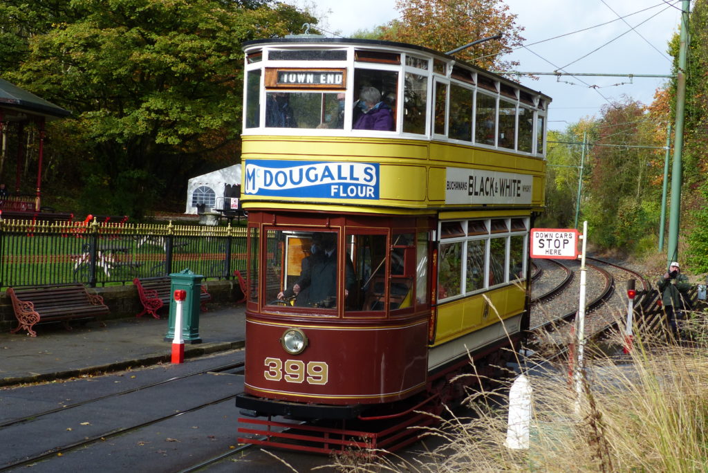 Double-deck electric tram in yellow and maroon, numbered 399