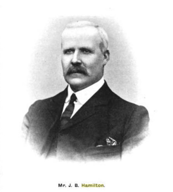 Balding man in a more modern business suit, moustache
