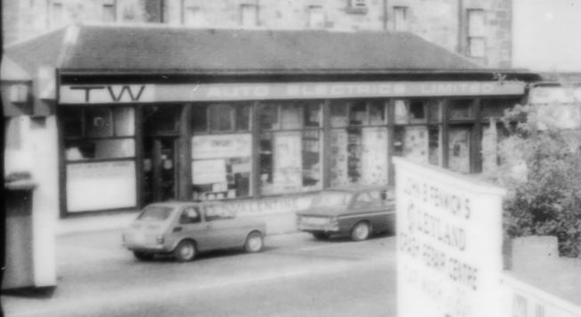 Blurry view of a single stoery building over the railway line, spotted in the corner of a photo of something else.