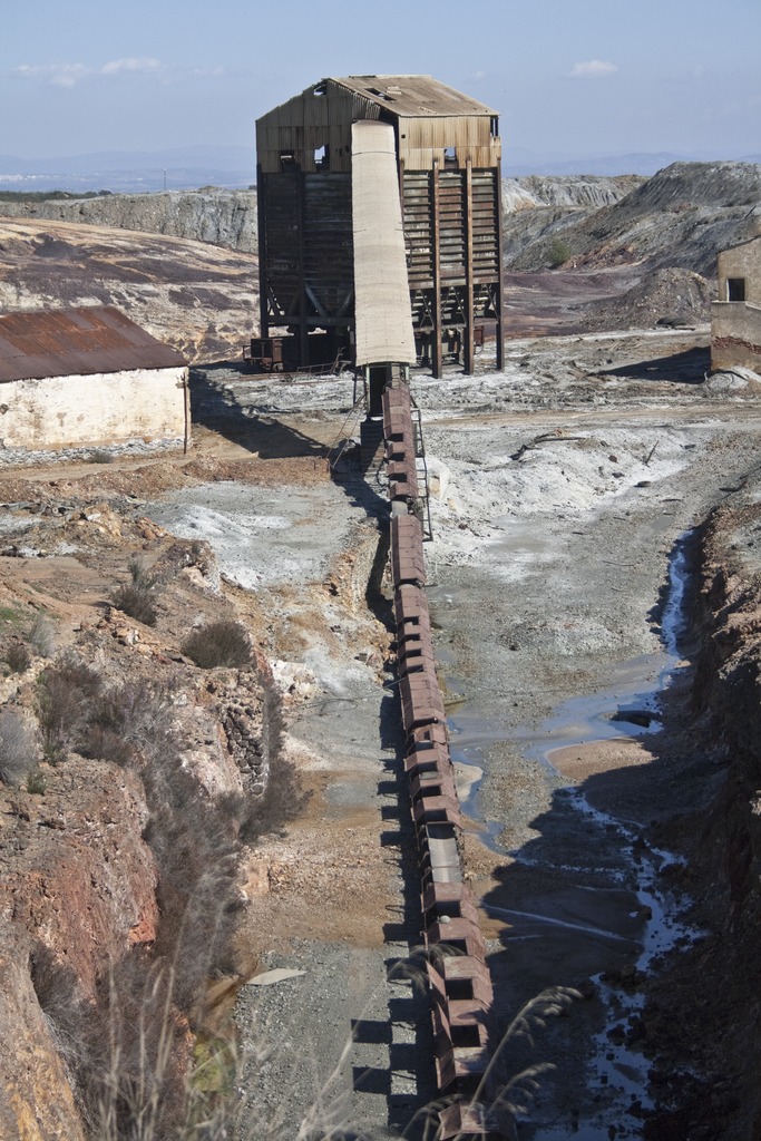 Abandoned mine building and conveyor in a desolate open cast mine