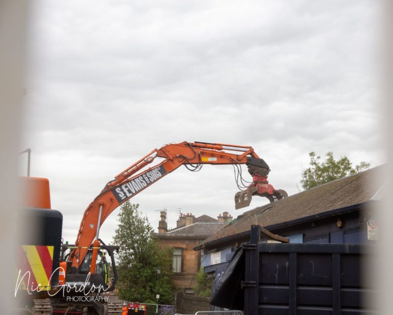 Excavator about to grab the roof of the booking hall